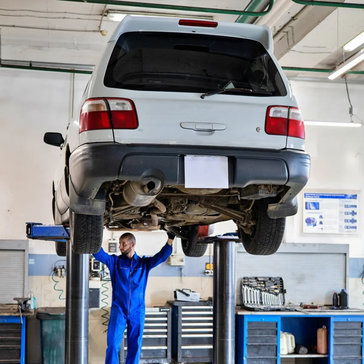 Technician inspecting a vehicle in a professional workshop